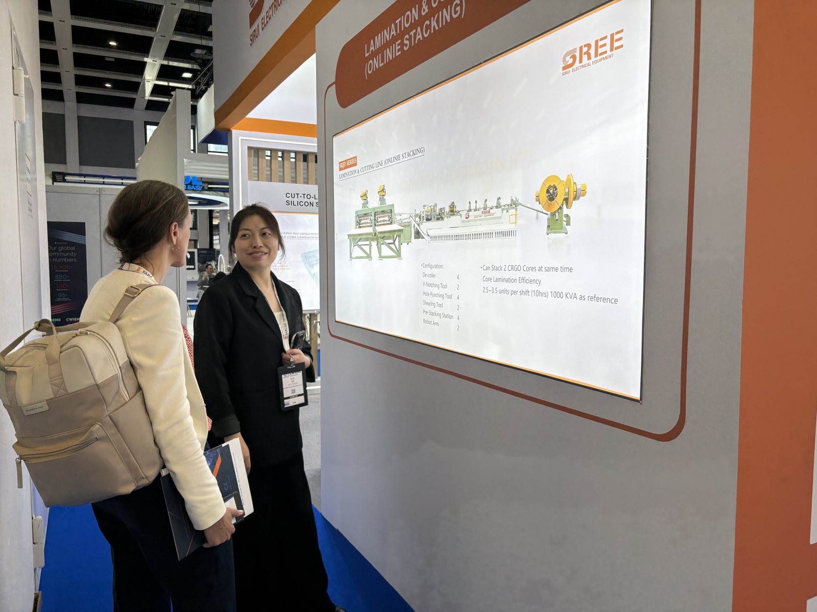 A visitor at the SREE stand at CWIEME Berlin 2026 looking at the SRJD lamination and cutting line with online stacking