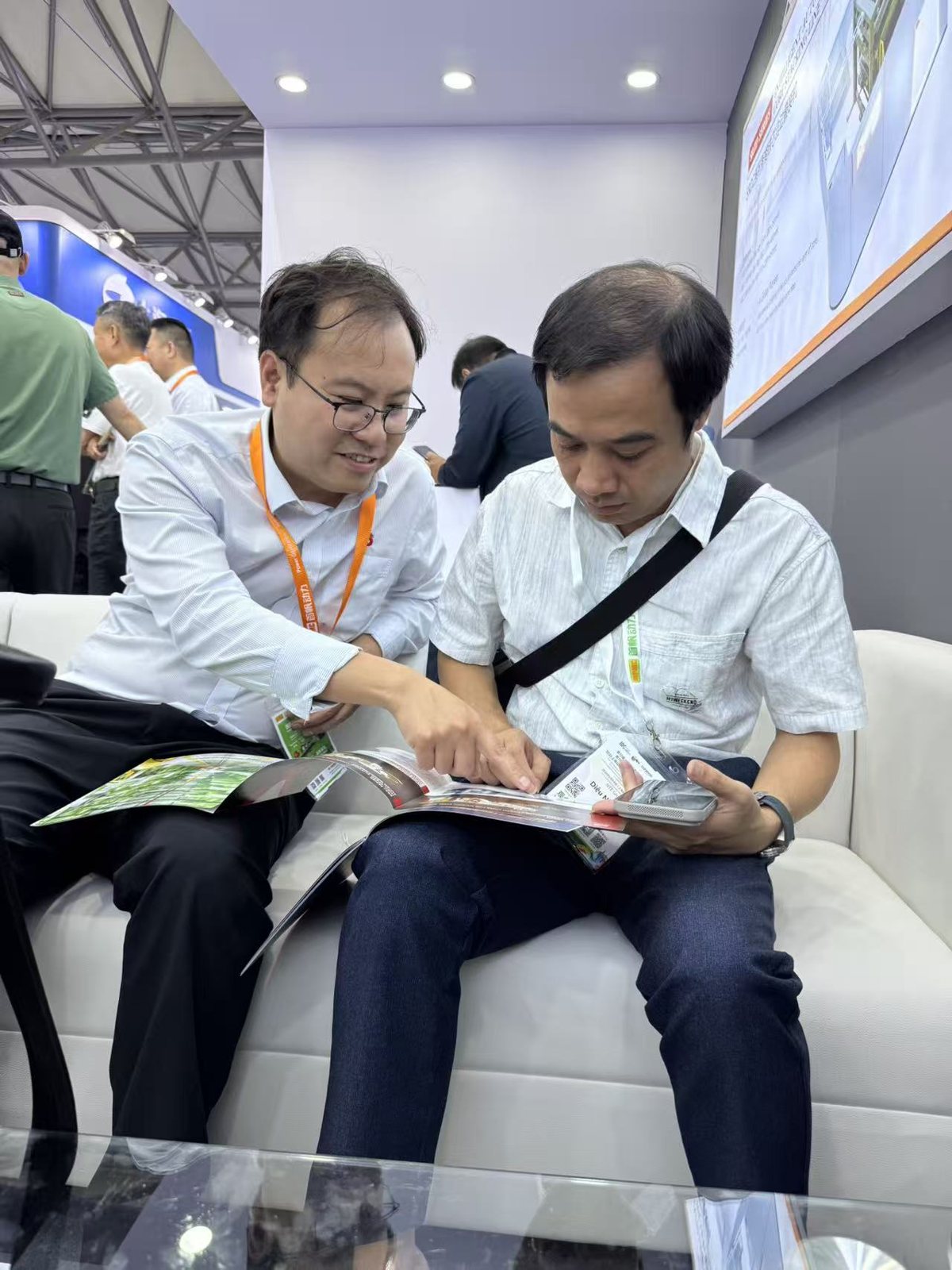 Reviewing a brochure with a visitor at the SREE stand, EPOWER 2026